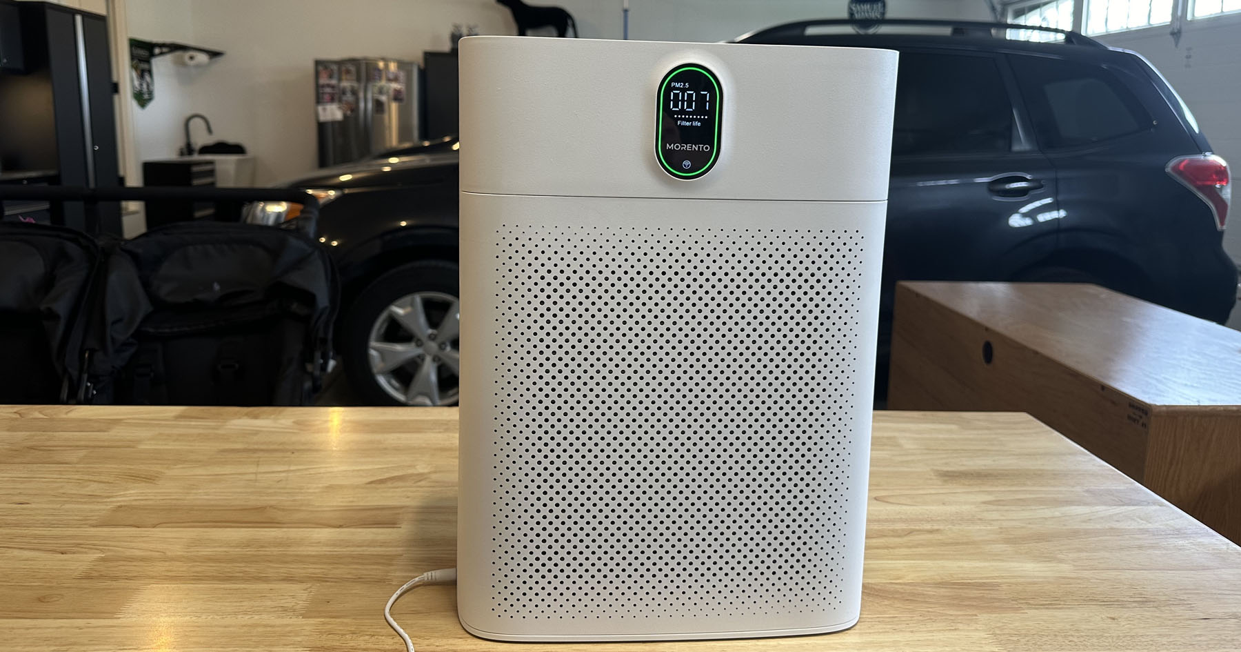 morento smart air purifier on a wooden table in a garage