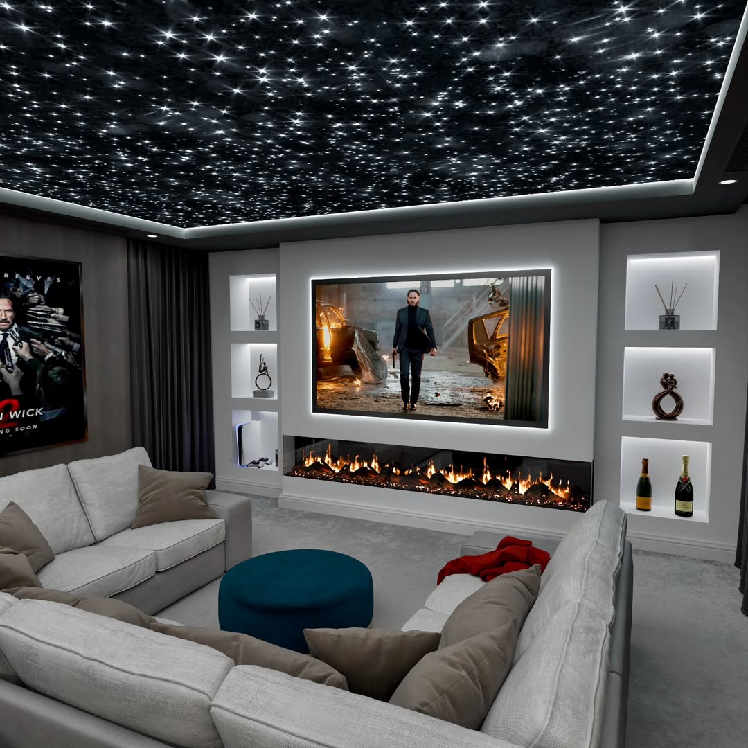 Modern home theater room with a large screen, starry ceiling lights, built-in shelves, electric fireplace, and a sectional sofa facing the screen.