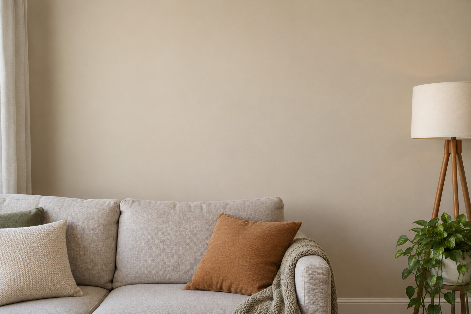 Plain empty living room wall beside a sofa and floor lamp