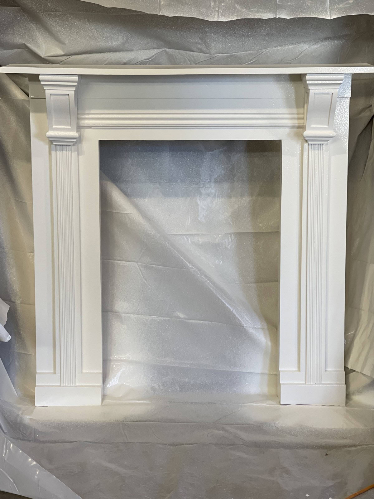 Freshly painted white wooden fireplace surround in a workshop
